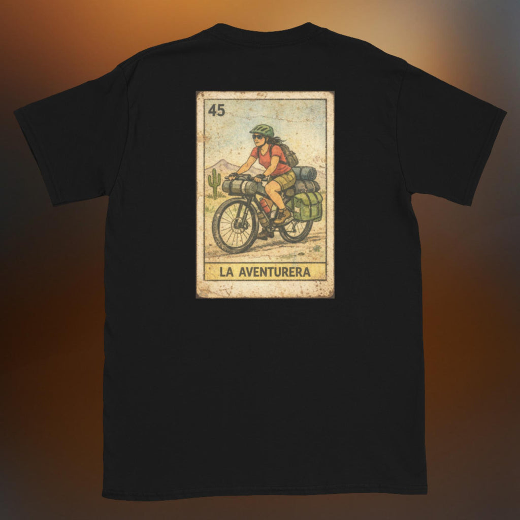 Latino apparel graphic tee featuring a vintage Mexican Loteria card design labeled "LA AVENTURERA" with a cyclist riding a bike, perfect for summer streetwear and cycling enthusiasts.