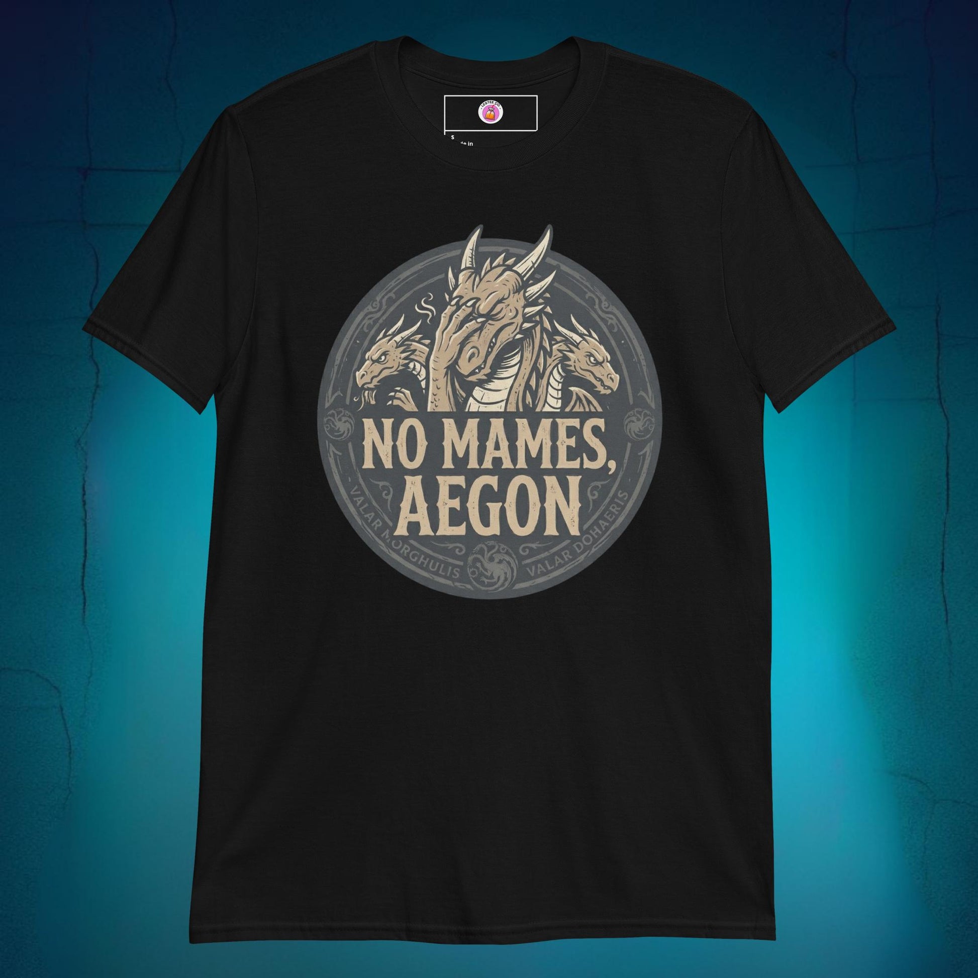 A close-up mockup of a unisex t-shirt featuring a graphic design of a dragon with a disappointed facial expression and the funny Spanish phrase text "no mames Aegon" written underneath.