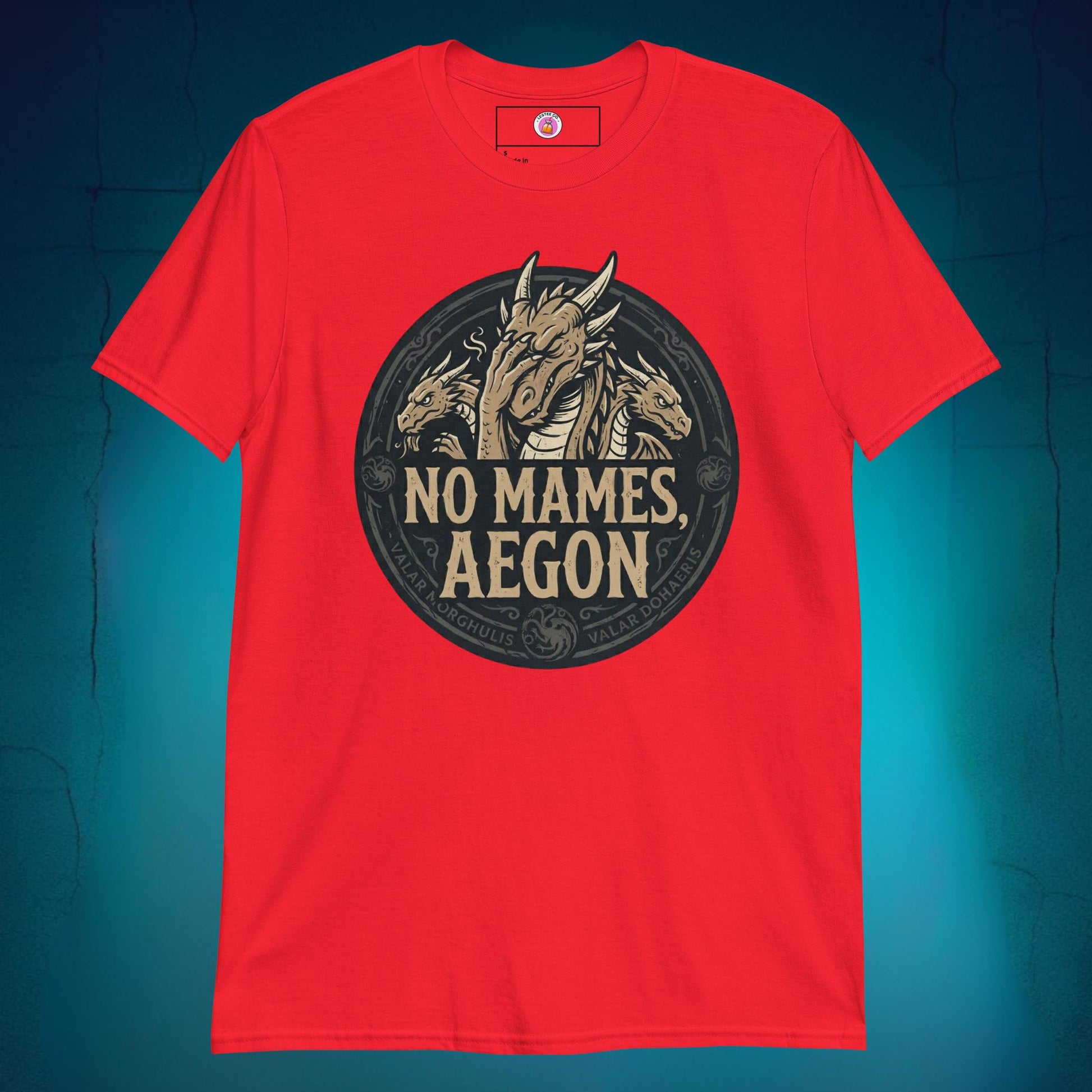 A close-up mockup of a unisex t-shirt featuring a graphic design of a dragon with a disappointed facial expression and the funny Spanish phrase text "no mames Aegon" written underneath.